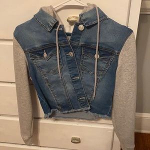 A jean jacket with sweatshirt sleeves and hood